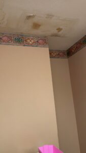Visible water stains and peeling paint on a ceiling from water damage, needing repair in Minneapolis, MN.