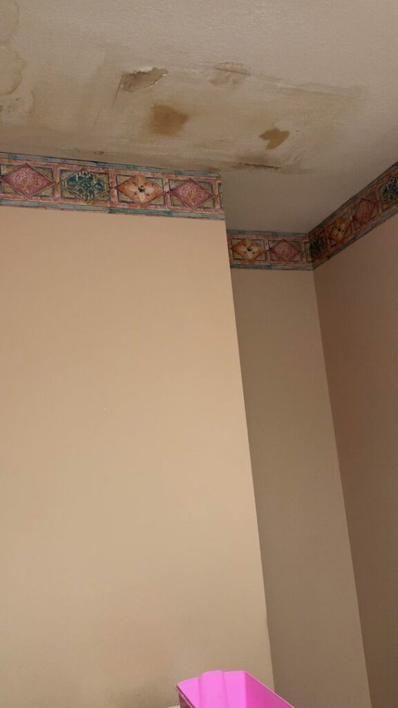 Visible water stains and peeling paint on a ceiling from water damage, needing repair in Minneapolis, MN.