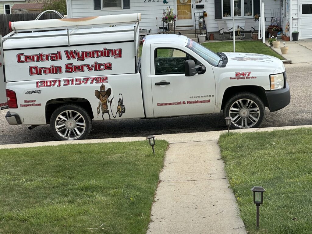 A branded service truck from Central Wyoming Drain Service parked on a residential street in Casper, WY.