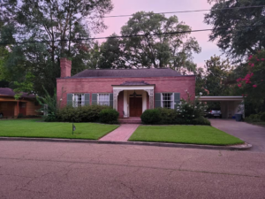 A charming house with a neatly mowed front lawn, reflecting the professional service of Caffey's Lawn Care LLC in Jackson, MS.