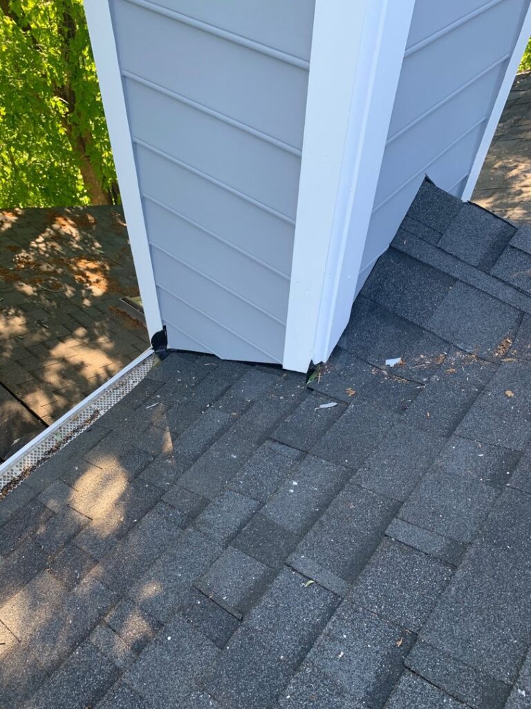 Close-up of a chimney with new light gray siding installed by Ultra Roofing in Cary, NC
