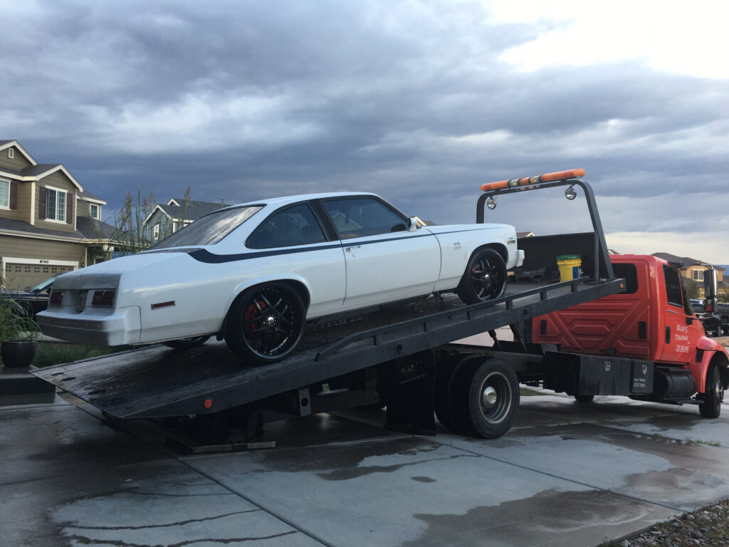 A white classic car loaded onto a flatbed tow truck by Towing Colorado in Colorado Springs, CO.