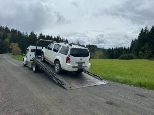 A classic brown car being towed with dollies by Speed's Towing in Vancouver, WA.