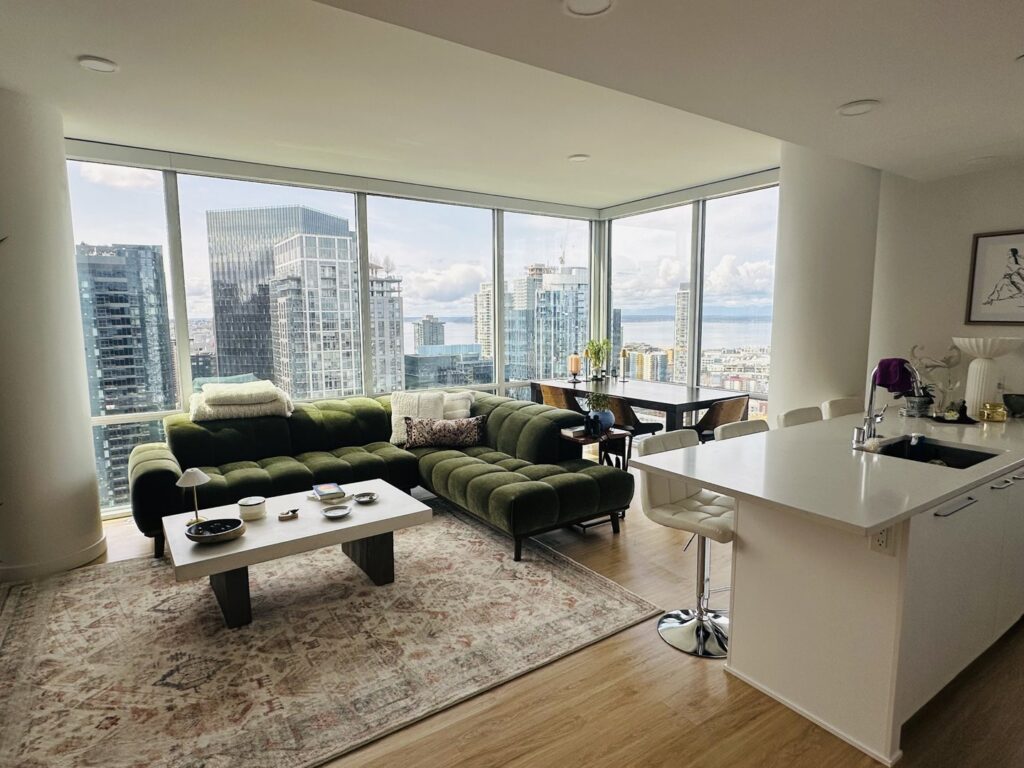 A clean and well-maintained apartment living room and kitchen area with stunning city views, reflecting the quality service of Quesada's cleaning services llc in Seattle, WA.