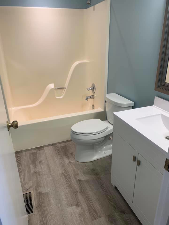 A freshly cleaned bathroom featuring a bathtub, toilet, and vanity, provided by Remy the Cleaner in Indianapolis, IN.