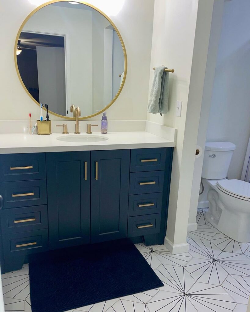 A modern and clean bathroom featuring a blue vanity and gold fixtures, highlighting house cleaning by Cleans by Roseileen LLC in Louisville, KY.