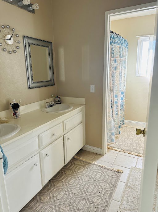 A spotless bathroom with a double vanity and a clean shower, maintained by Cleaning Service Masters LLC in Escondido, CA