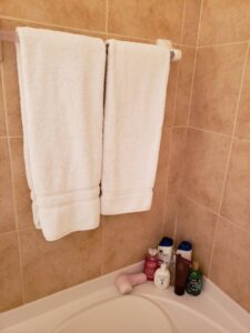 A clean bathroom with fresh white towels neatly hung, showcasing the results of Expert Cleaners LLC in Jacksonville, FL.