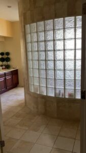 A sparkling clean bathroom with a glass block wall and tiled floor, showcasing the quality of Ragin Cleaning Services in Owings Mills, MD.