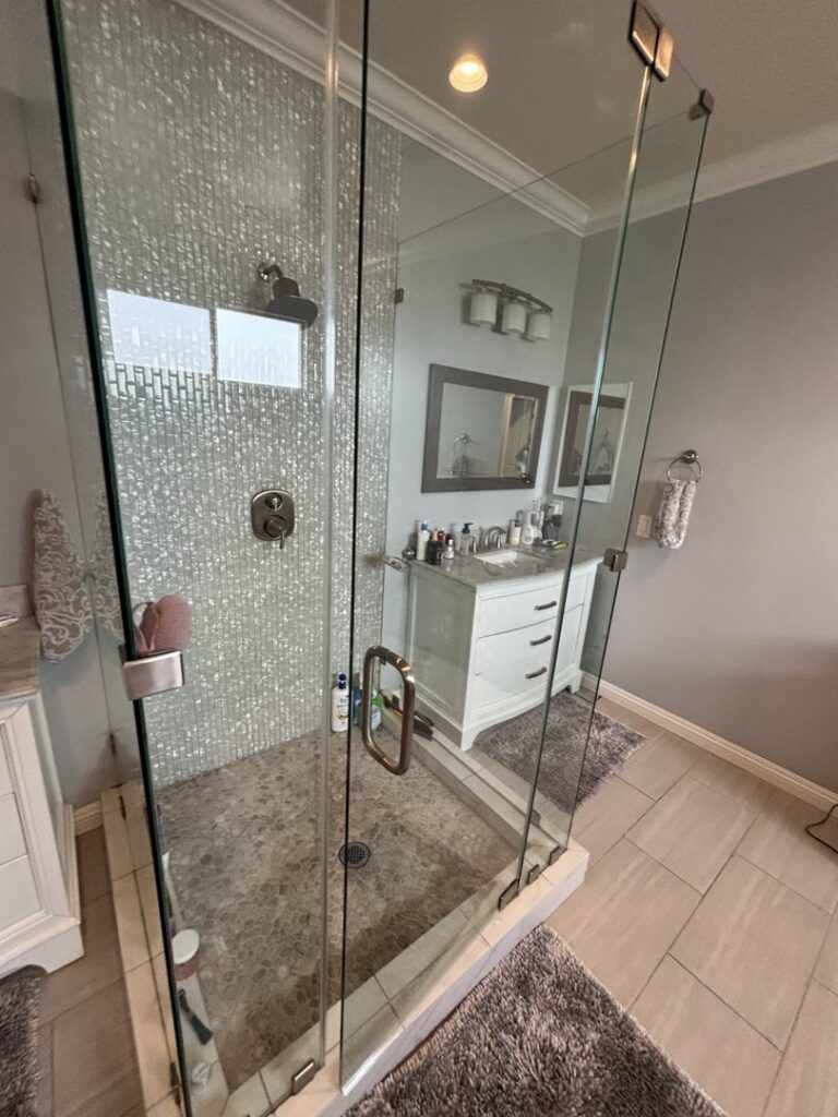 A pristine bathroom featuring a clear glass shower enclosure and a clean vanity, cleaned by Cleaning Service Masters LLC in Escondido, CA
