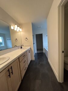 A spacious and clean bathroom with a long vanity and dark flooring, maintained by Martinez Cleaning Services in Kent, WA