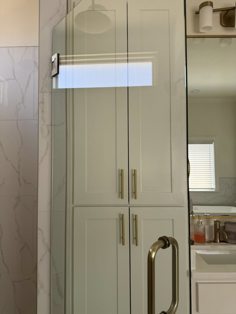 A clean bathroom featuring a glass shower and white built-in cabinets, professionally cleaned by Global Provisions, AR in Fayetteville, AR.