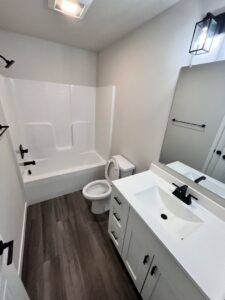 A meticulously cleaned bathroom featuring a shower-tub combination, vanity, and wet floor, indicating professional service by Cedar Cleaners LLC in Cedar Rapids, IA.