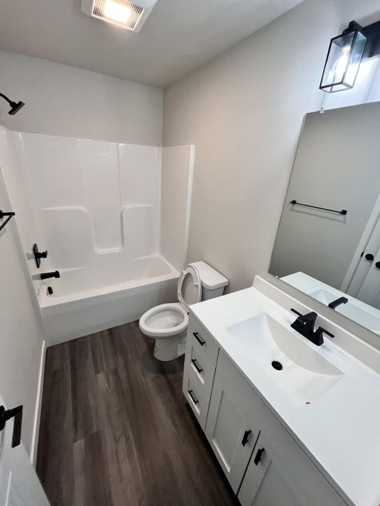 A meticulously cleaned bathroom featuring a shower-tub combination, vanity, and wet floor, indicating professional service by Cedar Cleaners LLC in Cedar Rapids, IA.