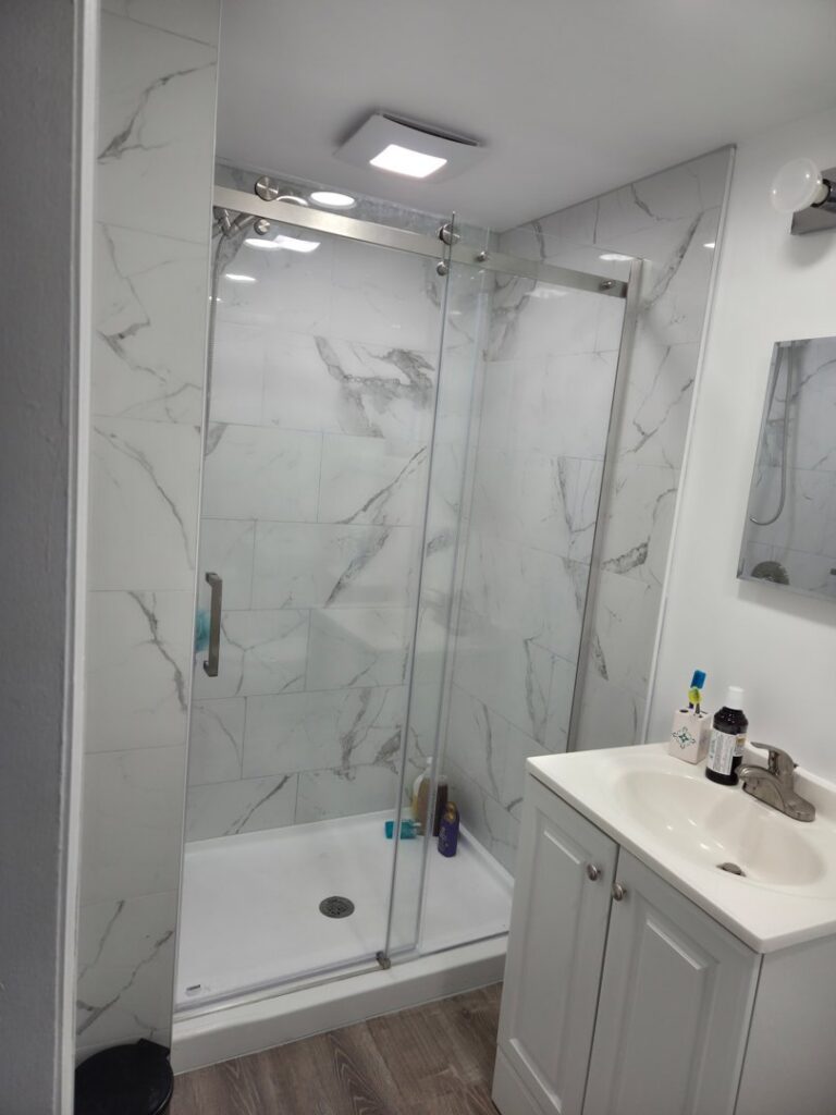 A clean bathroom with a glass shower and vanity after professional cleaning by Hm General Cleaning Services in Schenectady, NY