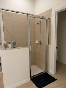A clean and well-maintained bathroom shower with beige tiles, showcasing the work of Nichole's Cleaning Service in Fort Wayne, IN