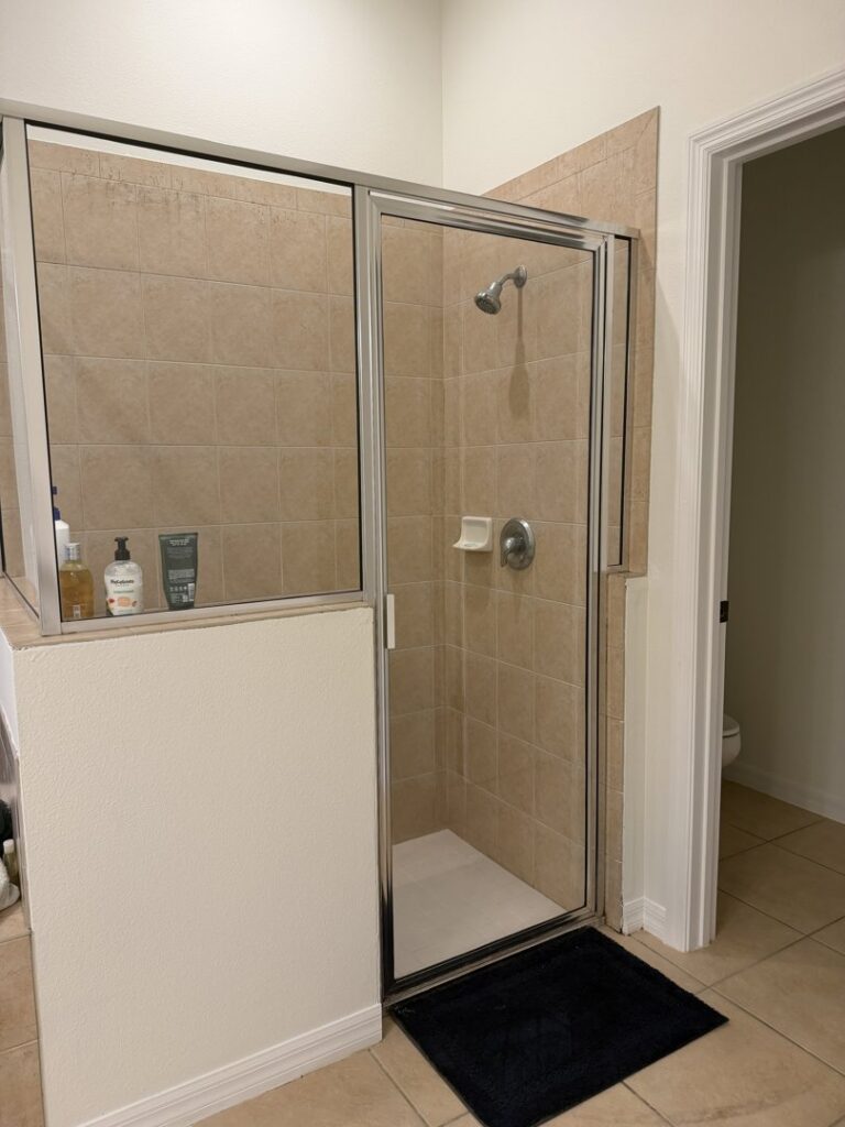 A clean and well-maintained bathroom shower with beige tiles, showcasing the work of Nichole's Cleaning Service in Fort Wayne, IN