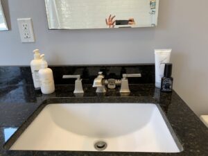 A sparkling clean bathroom sink and granite countertop, professionally cleaned by Maids & Multi Services by Landry, LLC in Bristol, CT.