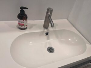 A spotless bathroom sink and modern faucet, demonstrating the meticulous cleaning provided by Nichelle's touch housekeeping LLC in Detroit, MI.