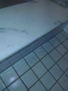 Clean bathroom tiles and a polished marble surface, showcasing the results from White Lotus Cleaning Services LLC in Nashua, NH.