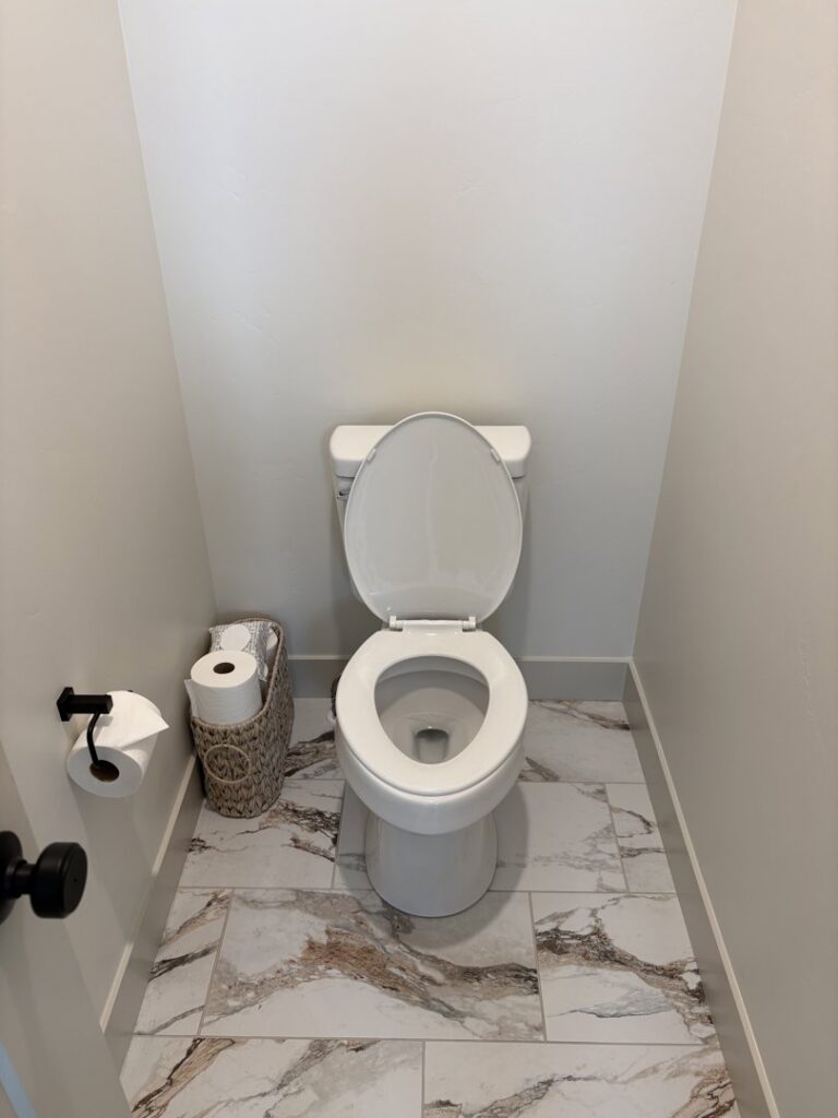 A sparkling clean bathroom with a white toilet and marble-patterned floor, showcasing Kleen Slate's results in Shakopee, MN.
