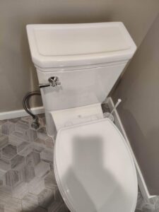 A clean toilet in a bathroom with modern hexagonal tiles after professional cleaning by Rebeccas Customized Cleaning LLC in Reading, PA.