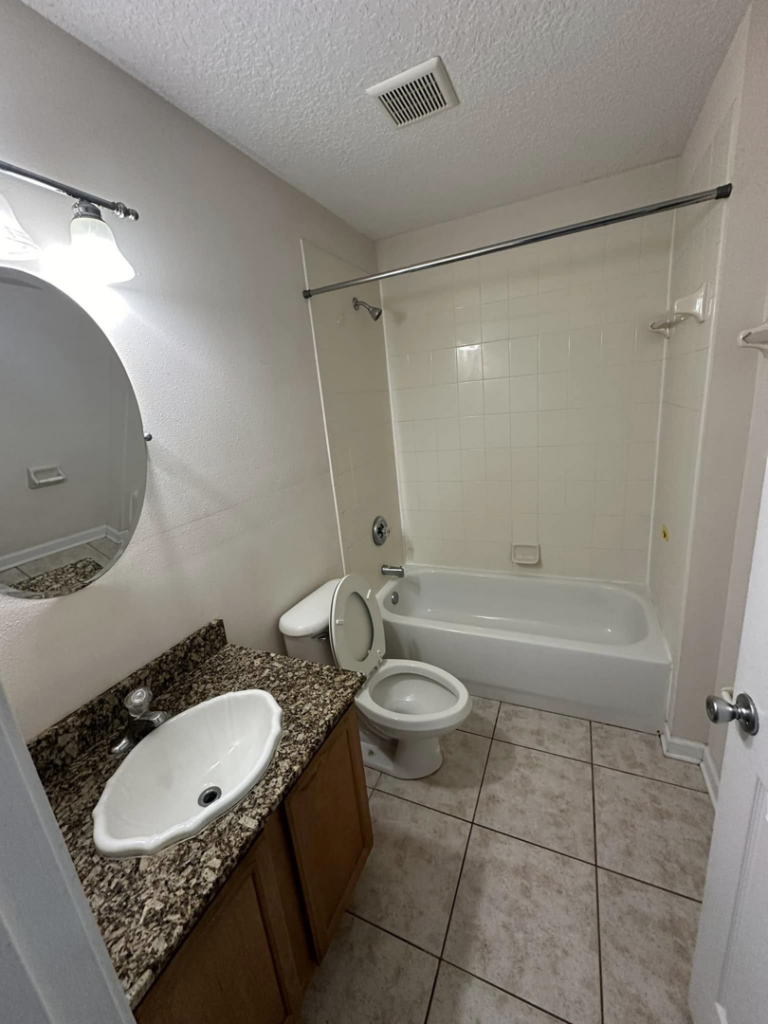 A clean bathroom featuring a toilet, sink, and bathtub, reflecting the quality house cleaning from CLEAN That SHEET LLC in Jacksonville, FL.