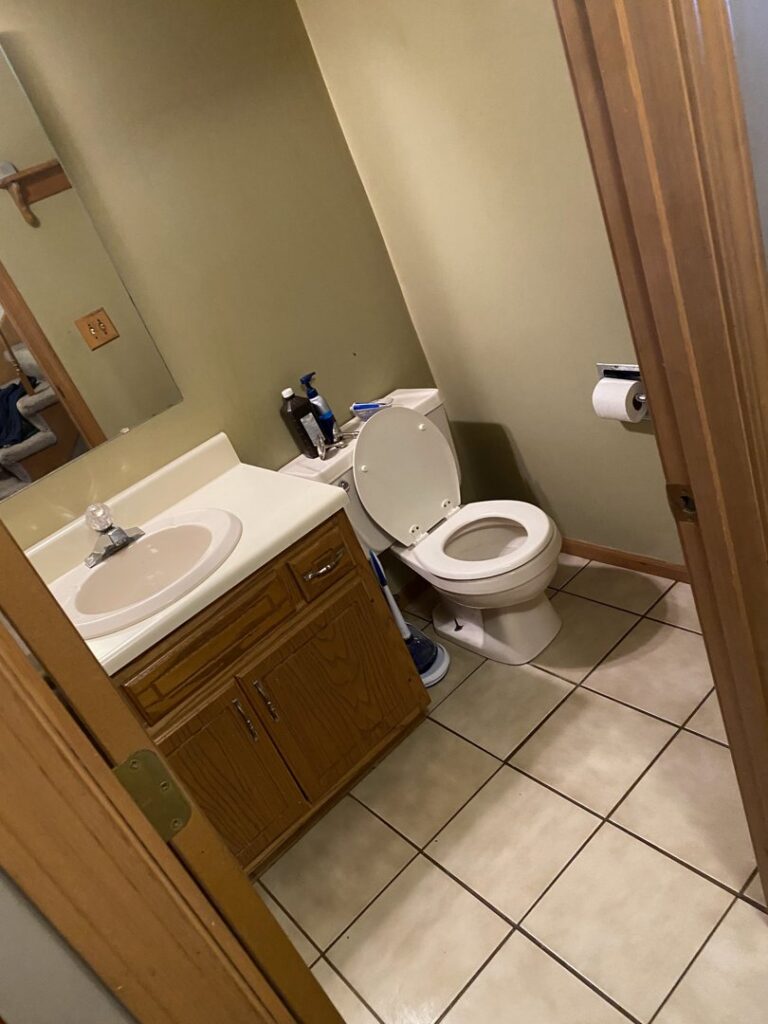 A clean bathroom with a toilet and sink, showcasing the meticulous cleaning provided by Final Touch & More in Fort Wayne, IN