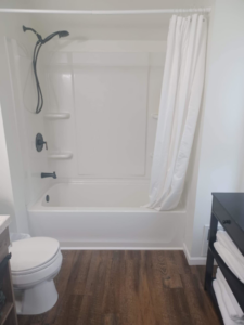 A sparkling clean bathroom with a white tub, shower, and toilet, showcasing the results of A+ Residential Cleaning Services in Champaign, IL.