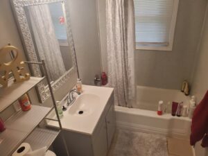 A clean bathroom vanity with a sink and mirror, showcasing the meticulous cleaning services of Perfection Cleaning in Kansas City, MO.