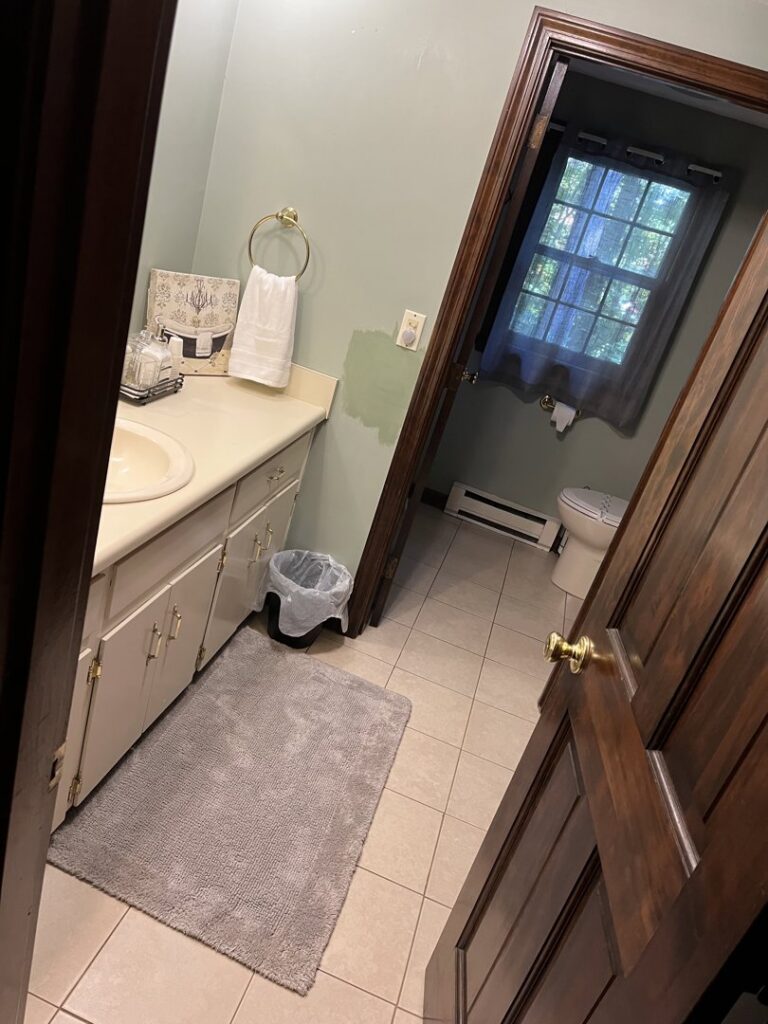 A clean bathroom vanity area with a sink, mirror, and tidy floor, showcasing the work of Make It Shine in Worcester, MA