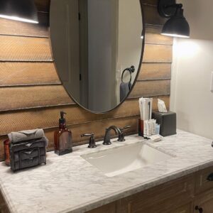 A spotless bathroom vanity with a marble countertop and neatly arranged toiletries, showcasing house cleaning by Cleans by Roseileen LLC in Louisville, KY.