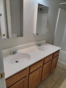A clean bathroom vanity with double sinks and wooden cabinets, showcasing the detailed cleaning by AG Simply Clean in Concord, NC.