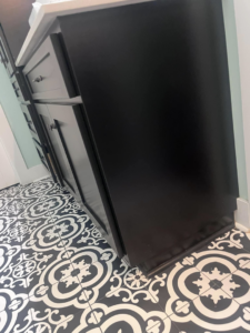 A meticulously cleaned black bathroom vanity and patterned floor tiles by Blue Line Cleaning Services in Rock Hill, SC.