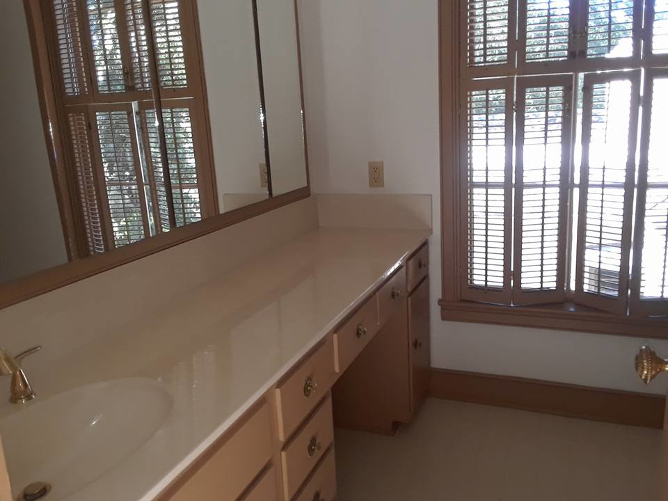 A sparkling clean bathroom vanity with a sink and mirror, showcasing house cleaning services by Inside & Out Residential Cleaning & Lawn Care in Yulee, FL.