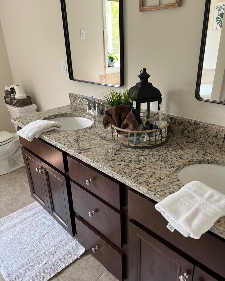 A beautifully clean bathroom vanity with two sinks and fresh towels, showcasing the results of Mary's Sparkling Cleaning in Fall River, MA.