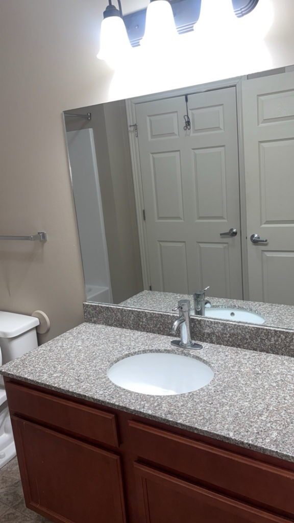 A spotless bathroom vanity with a clean sink and mirror, demonstrating expert house cleaning services by NACleaning Co. in Omaha, NE.