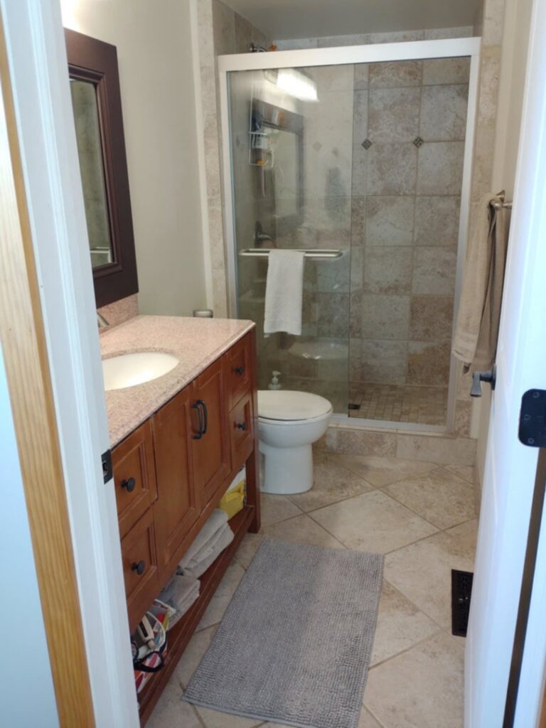 A pristine clean bathroom featuring a modern vanity, sink, and glass shower, cleaned by A+ Residential Cleaning Services in Champaign, IL.
