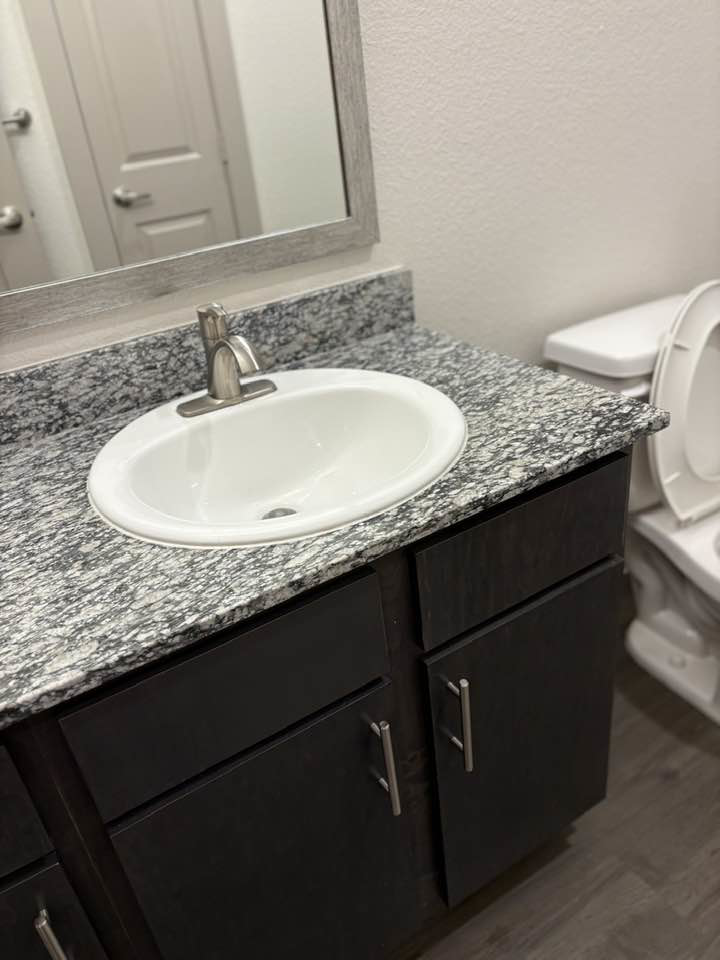 A sparkling clean bathroom vanity and sink, expertly cleaned by Jess Cleaning in San Antonio, TX.