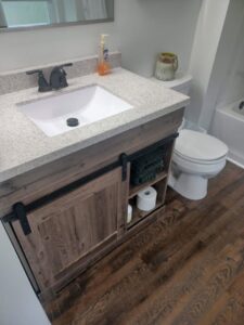 A freshly cleaned bathroom vanity with a white sink and toilet, demonstrating the quality work of A+ Residential Cleaning Services in Champaign, IL.