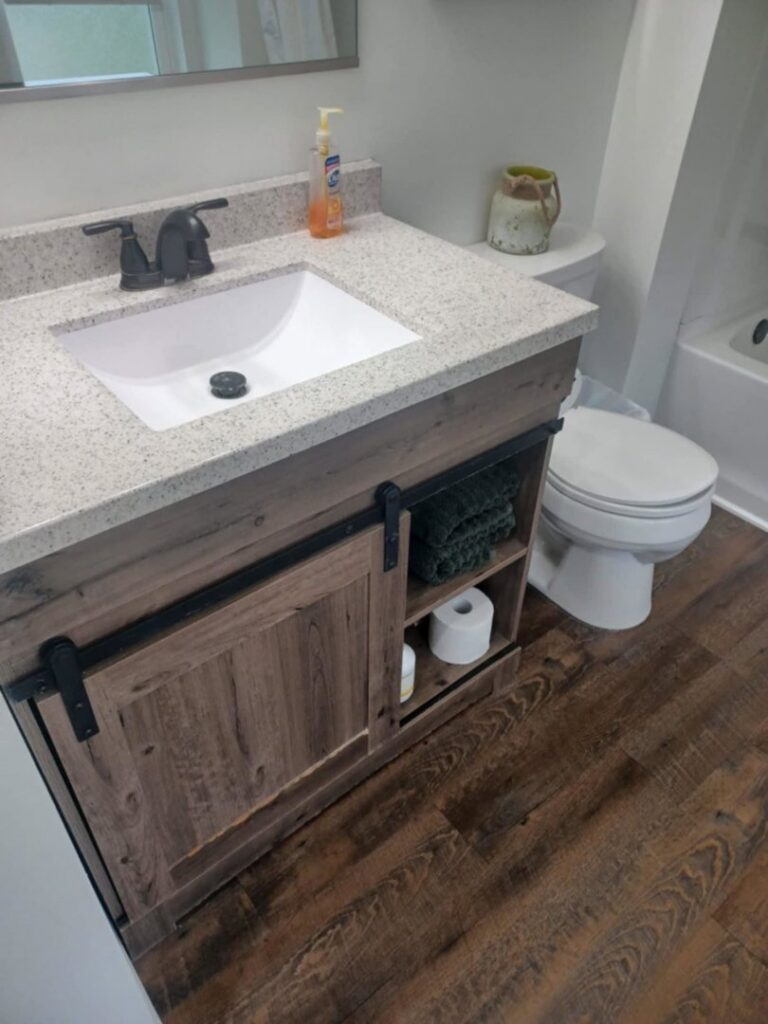 A freshly cleaned bathroom vanity with a white sink and toilet, demonstrating the quality work of A+ Residential Cleaning Services in Champaign, IL.
