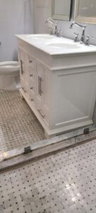 Clean bathroom vanity with two sinks and sparkling glass shower door, showing results of cleaning by Jolley Services, INC in Bossier City, LA.