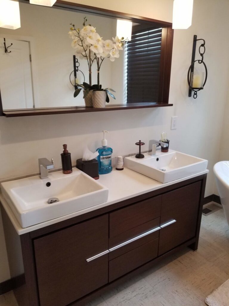 A clean bathroom vanity with two white sinks and a large mirror by Cooper-N-Folks in Philadelphia, PA