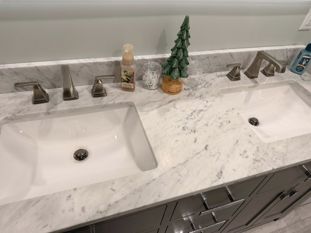 A pristine bathroom vanity with dual sinks and marble countertop cleaned by Jocelyn's Cleaning Services in Charlotte, NC.