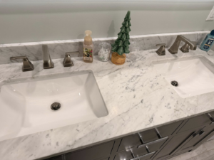 A pristine bathroom vanity with dual sinks and marble countertop cleaned by Jocelyn's Cleaning Services in Charlotte, NC.