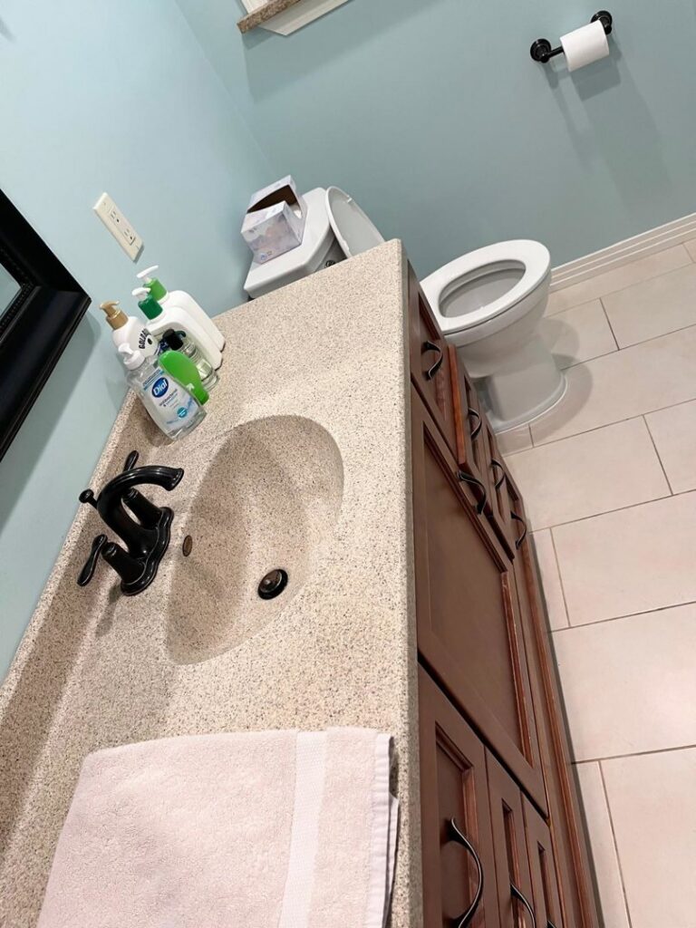 A clean and tidy bathroom vanity and toilet, reflecting the professional house cleaning services of Nichelle's touch housekeeping LLC in Detroit, MI.