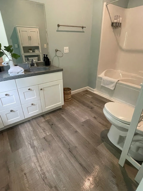 A meticulously clean bathroom featuring a vanity, toilet, and tub, provided by Straight Up Cleaning in South Portland, ME.