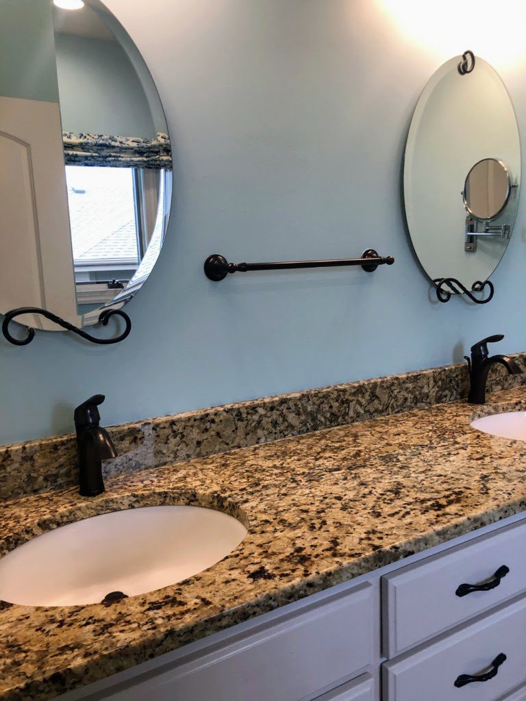 A spotless bathroom vanity with double sinks and mirrors, cleaned by Price Cleaning Services Omaha in Council Bluffs, IA.