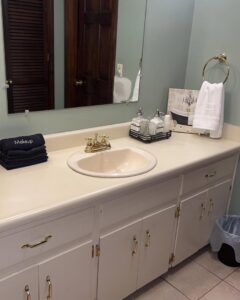 A clean bathroom vanity with a sink, neatly folded towels, and organized accessories by Make It Shine in Worcester, MA