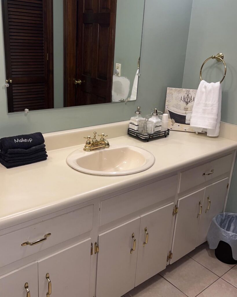 A clean bathroom vanity with a sink, neatly folded towels, and organized accessories by Make It Shine in Worcester, MA